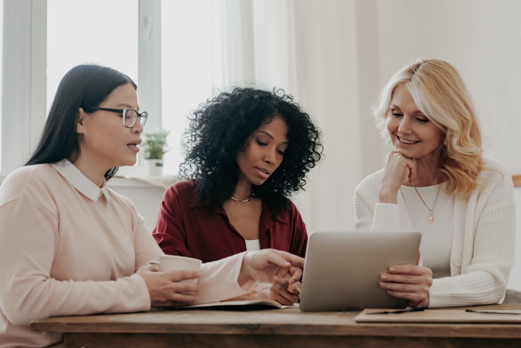 Three confident middle-aged and older women reviewing financial documents together